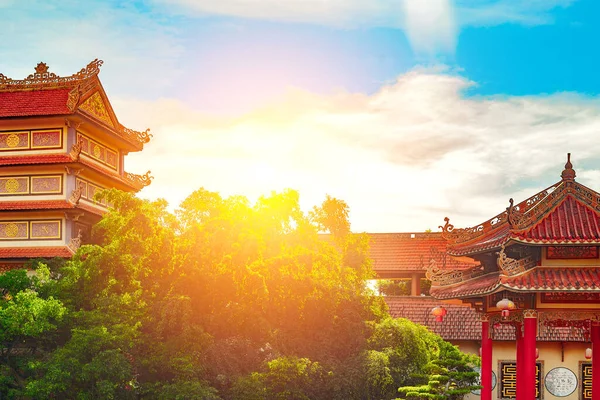 Güneşli geleneksel Çin mimarisi, yemyeşil ve berrak gökyüzü.