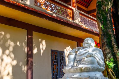 Güneşli Asyalı tapınak bahçesinde heykel.