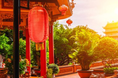 Geleneksel Asya fenerleri gün batımında huzurlu bir tapınak avlusunu süsler..