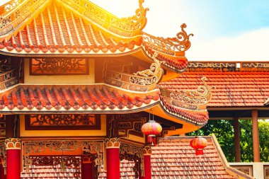 Kırmızı çatılı ve güneş ışığıyla süslenmiş Asya tapınağı mimarisi.