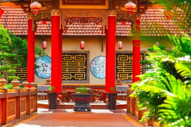 Geleneksel Asya mimarisi, kırmızı sütunlar ve fenerlerle sakin bir bahçe sahnesinde..