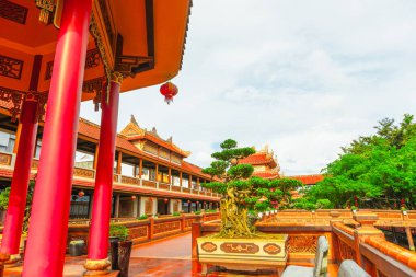 Geleneksel Asya tapınak avlusu canlı kırmızı sütunlar ve yemyeşil.