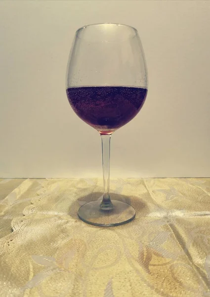 Ψηλό διάφανο γυάλινο κύπελλο με σκούρο κόκκινο κρασί σε διάφανο φόντο — Φωτογραφία Αρχείου