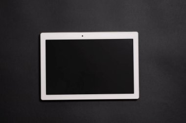 Siyah arka planda beyaz tablet var. Yatay olarak konumlandırılmış boş siyah yazma alanı olan bir ekran.