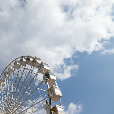 Bir lunaparkta dönme dolap Beyaz ve mavi gökyüzüne karşı