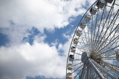 Bir lunaparkta dönme dolap Beyaz ve mavi gökyüzüne karşı