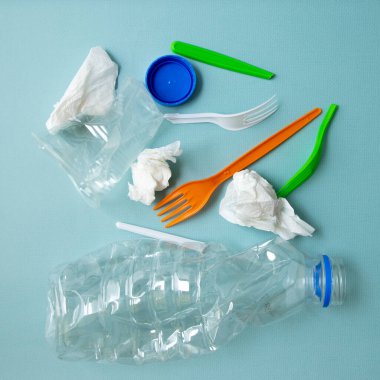 Mavi arka planda çeşitli plastik çöpler, atık sıralama ve geri dönüşüm konsepti, üst görünüm