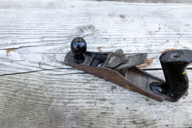 Eski alet. Tahta bir masanın üzerinde metal bir planör yatıyor. Ahşap çalışma aracı.