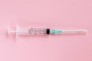 Pembe arka planda tek kullanımlık şırınga. Sağlık ve İlaç Hizmetleri.