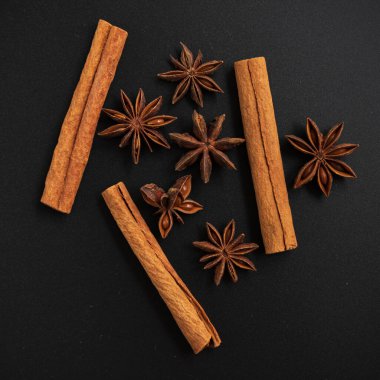 Tarçın ve yıldız anason çubukları. Karanlık arka plan. Düz yatıyordu. Üst görünüm