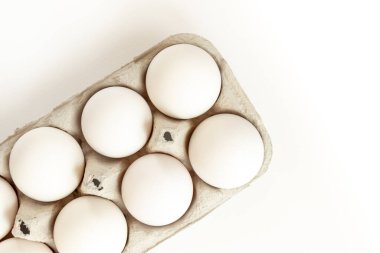 Kutuda beyaz tavuk yumurtası. Beyaz arka planda tavuk yumurtaları olan karton yumurta kutusu..