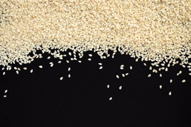 Siyah arkaplanda beyaz susam çerçevesi izole edilmiş. Üst görünüm, yakın çekim.