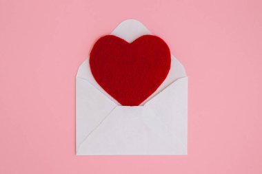Pembe arka planda büyük kırmızı kalbi olan beyaz bir zarf aç. Kalpli bir aşk mektubu. Sevgililer Günü, Anne, Kadınlar Günü Selamları.