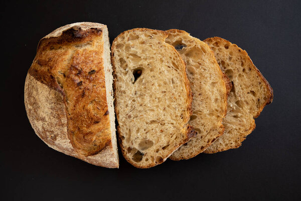 Fresh sliced whole grains bread on a black background. Slices of sliced bread. View from above.