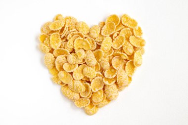 Beyaz arka planda izole edilmiş mısır gevreğinden yapılmış kalp. Üst görünüm.