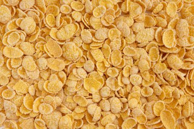 Mısır gevreği arka planda. Mısır gevrekleri masaya saçılmış. Üst görünümü kapat.