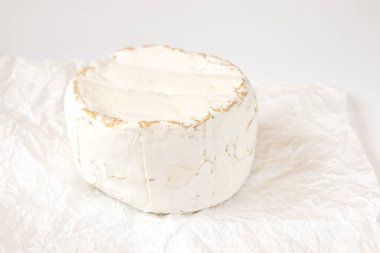 Peynirli camembert veya peynirli beyaz arkaplan, beyaz parşömen kağıdında peynir, lezzetli camembert veya brie peyniri, Fransız peyniri