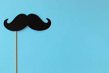 Fotoğraf kabini mavi arka planda siyah bıyığı destekliyor, mutlu babalar günü.