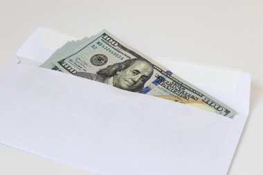 Beyaz arka planda izole edilmiş bir zarf içinde dolar banknotları