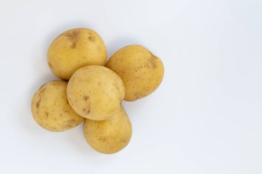 Beyaz arka planda izole edilmiş taze patates yığını, çiğ sebzeler, üst manzara.