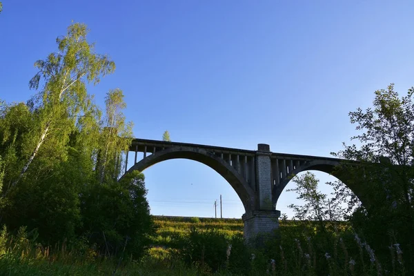 An old 100-year-old railway viaduct across the Iren River near the Bartym station next to the modern railway line.