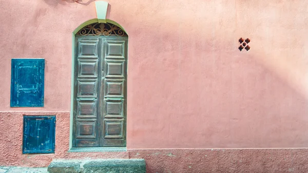 Puerta vieja en la pared de color rosa con espacio de copia — Foto de Stock