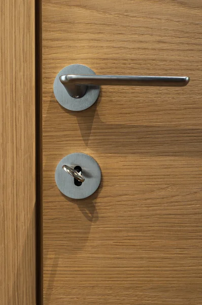 Moderne, eigentijdse satijnen handgreep op een houten deur — Stockfoto