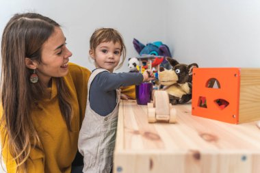 Kızıyla oyun odasında ödeme yapan genç bir kadın.