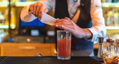 Barmen gece kulübünde kokteyl hazırlıyor.