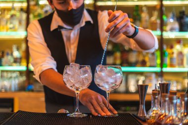 Barmen gece kulübünde kokteyl hazırlıyor.