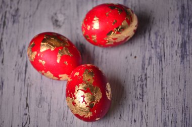 Üç renkli el yapımı Paskalya yumurtaları altın ile