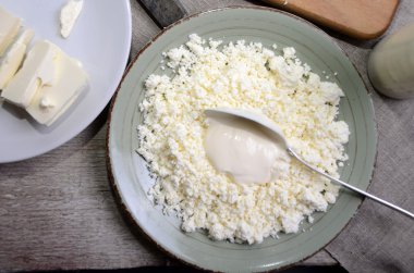 Organik tarım süzme peynir bir mavi kase, ekşi krema ve süt