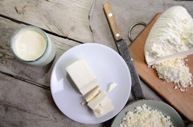 Süt ürünleri ahşap masa üzerinde. Süt, peynir, lor peynir ve tereyağı. Kopya alanı ile Üstten Görünüm