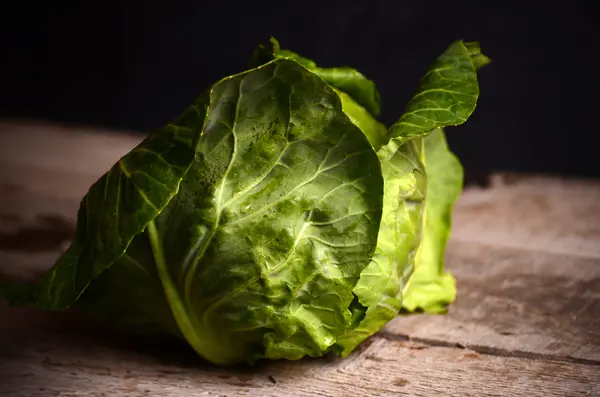 Kırsal ahşap arka planda taze yeşil bahçe lahanası.