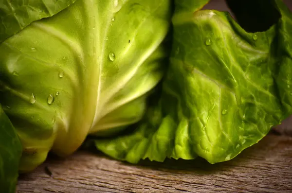 Kırsal ahşap arka planda taze yeşil bahçe lahanası.