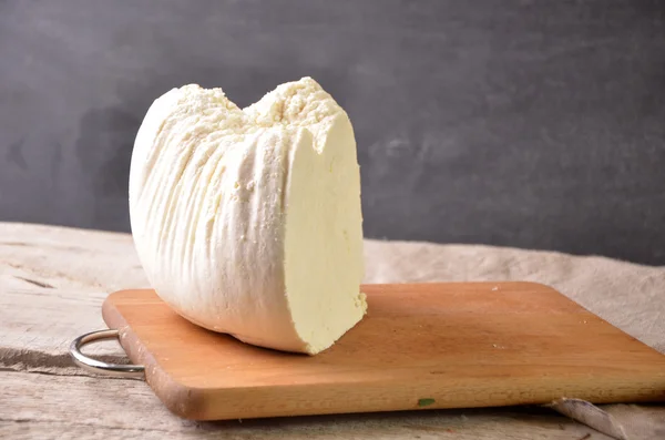 Fromage cottage frais dans un bol blanc avec cuillère sur une table en bois . — Photo