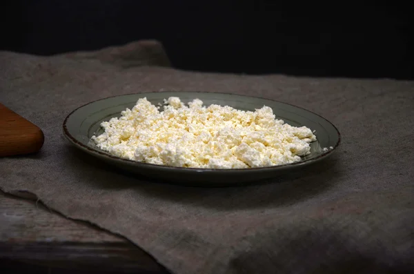 Fromage cottage frais dans un bol blanc avec cuillère sur une table en bois . — Photo