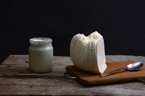 Ricotta fresca in una ciotola bianca con cucchiaio su un tavolo di legno . — Foto Stock