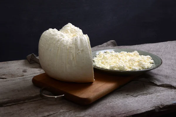 Ricotta fresca in una ciotola bianca con cucchiaio su un tavolo di legno . — Foto Stock