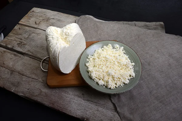 Ricotta fresca in una ciotola bianca con cucchiaio su un tavolo di legno . — Foto Stock