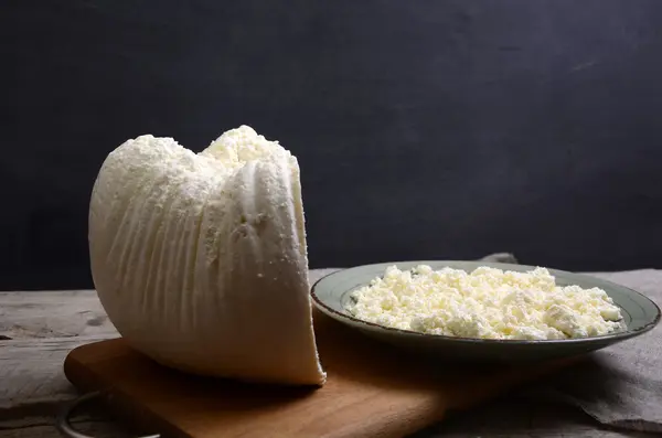 Ricotta fresca in una ciotola bianca con cucchiaio su un tavolo di legno . — Foto Stock