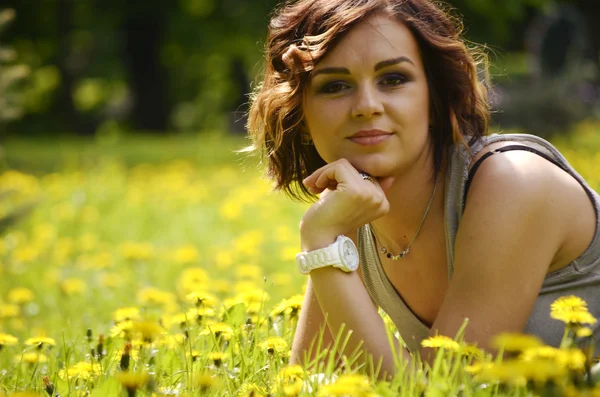 Genç güzel kadın yaz gün batımında çim üzerinde yalan. doğal mutluluk, eğlence ve uyum. — Stok fotoğraf