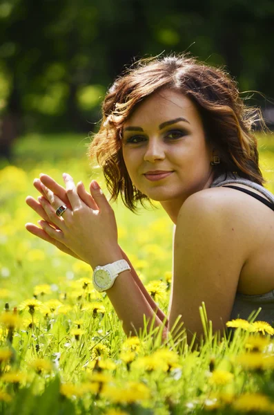 Junge hübsche Frau, die bei Sonnenuntergang im Gras liegt. Natürliches Glück, Spaß und Harmonie. — Stockfoto