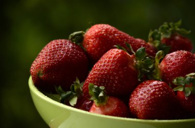 Ahşap arka plan, seçici odak üzerinde papatya ile plaka tatlı Yaban çilekleri