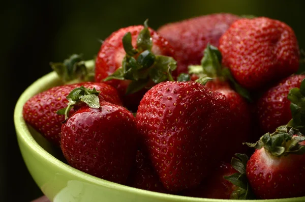 Fresas dulces silvestres en plato con margaritas sobre fondo de madera, enfoque selectivo — Foto de Stock