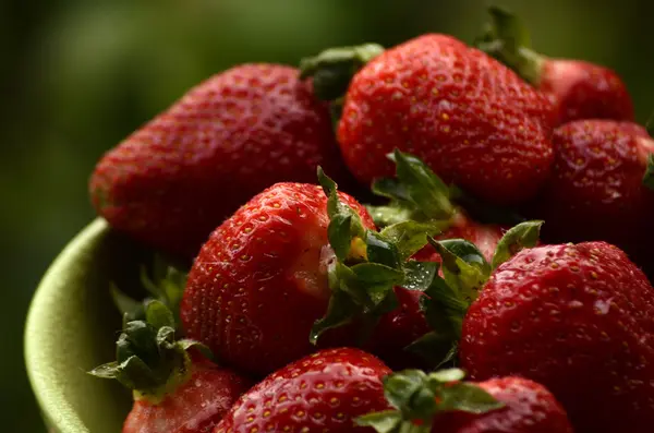 Fresas frescas maduras en un tazón blanco simple, sobre una mesa de madera — Foto de Stock