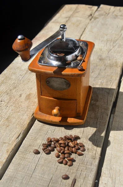 Moedor de café vintage e grãos no fundo de madeira — Fotografia de Stock