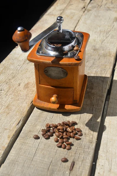 Vintage coffee grinder and beans on wooden background — Stock Photo, Image