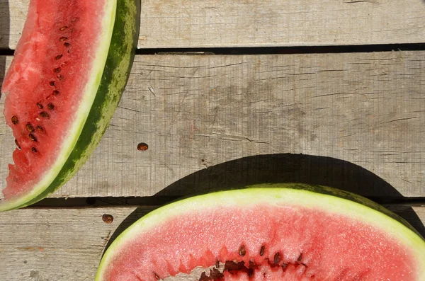 Mogen vattenmelon på wicker bricka på bordet på trä bakgrund — Stockfoto