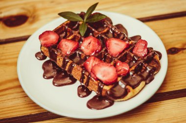 Hamburger patates ile beyaz bir plaka üzerinde yatıyor